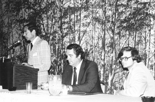 General Chairman Richard Gabel welcomes the attendees of Mideast Regional Symposium. Seated are Jeff McDonald, Chairman of the first session, and Technical Chairman Frank Tarzanin.

From Vertiflite, September/October 1976